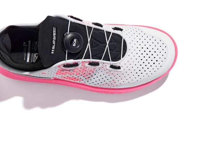 View of black, white, and pink Under Armour shoes.